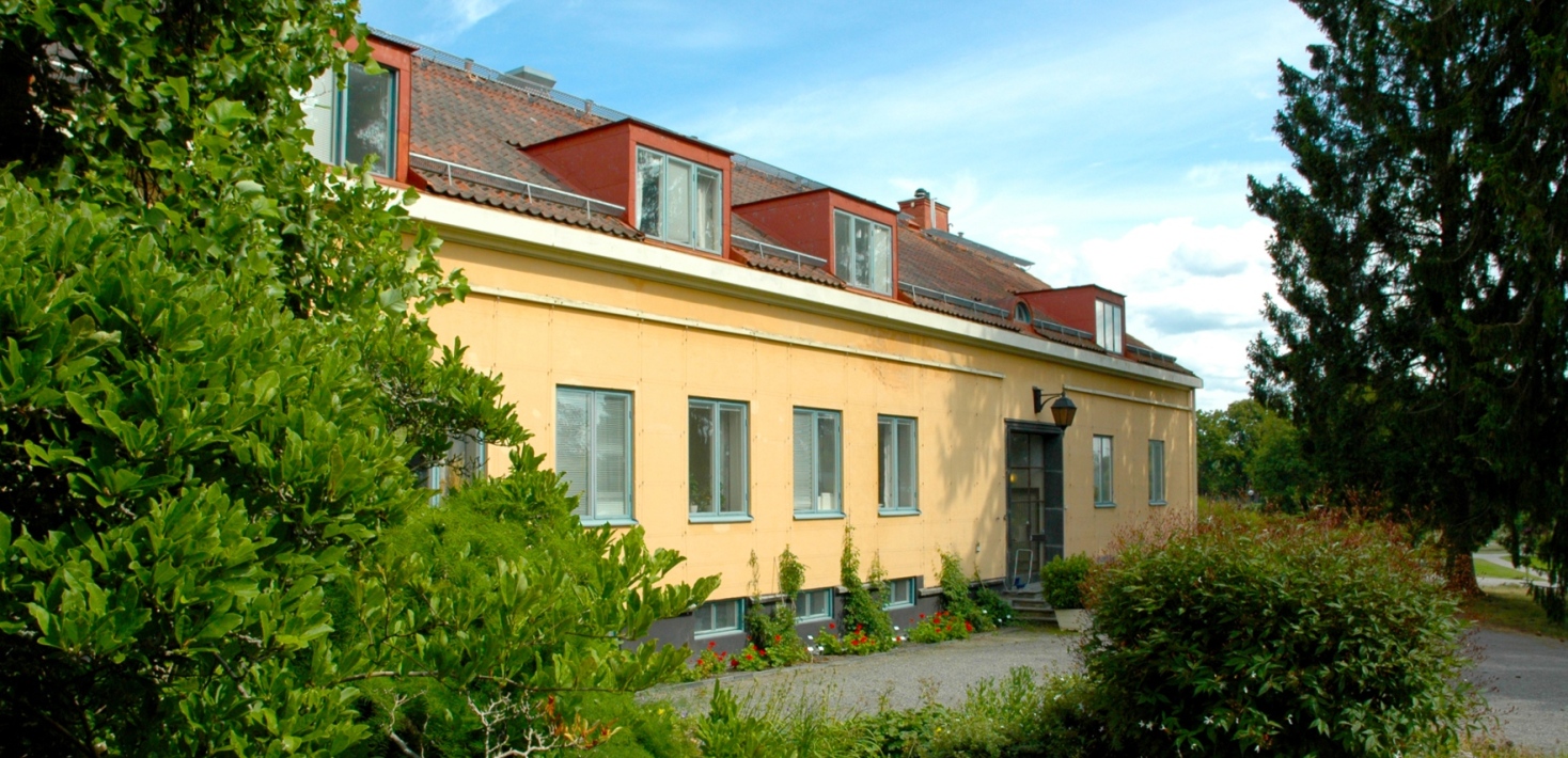 En gul byggnad omgärdad av grönska. Foto AnnSofie Börjesson.